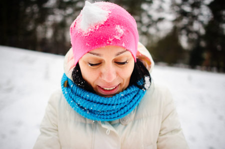 Charming young woman plays with someone in snowballs. The first snow and winter entertainments very...