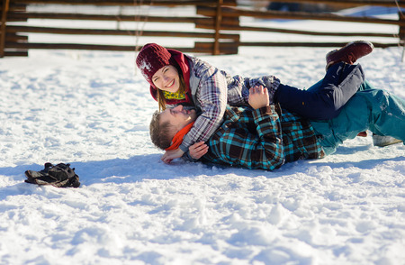 Young couple cheerfully flounders in snowの写真素材