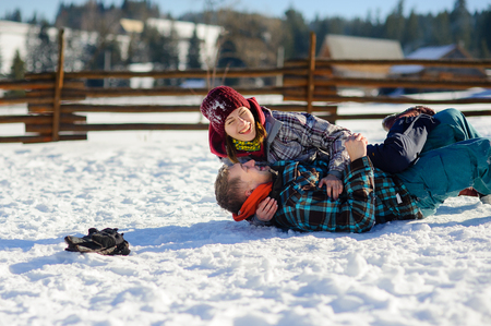 Young couple cheerfully flounders in snowの写真素材