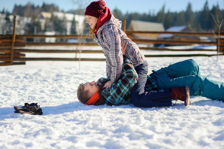 Young couple cheerfully flounders in snowの写真素材