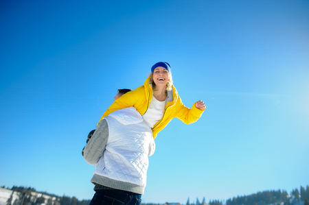 Young man holding in his arms his girlfriend. Man sturdily built easily picks up a fragile girl. Young people having fun. Against the background of the blue sky.の写真素材