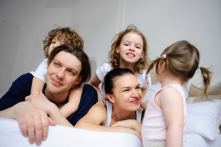 Morning in a big family. Father, mother and three children cheerfully begin new day.の写真素材