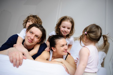 Morning in a big family. Father, mother and three children cheerfully begin new day.の写真素材