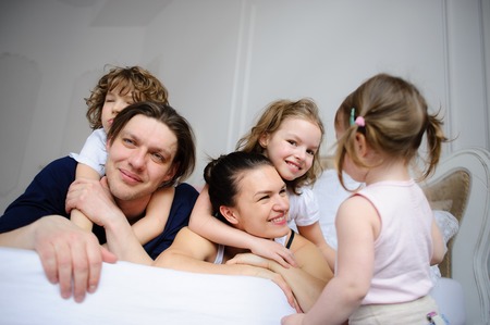Morning in a big family. Father, mother and three children cheerfully begin new day.の写真素材