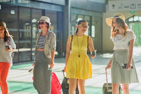 Charming young tourists at the station. In hands baggage, tickets, passports. Summer holiday. Excellent mood.の写真素材