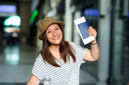 Cheerful tourist with the passport and tickets. Summer holiday. Railway station.の写真素材