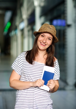 Cheerful tourist with the passport and tickets. Summer holiday. Railway station.の写真素材