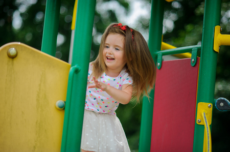 The charming little girl plays in the jungle gym. To the child it is very cheerful.の写真素材