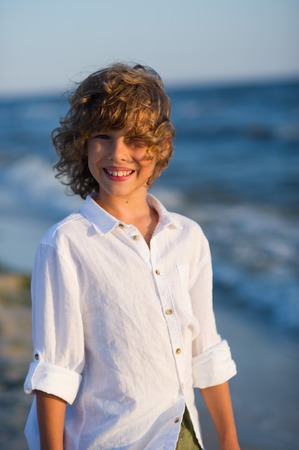 Portrait of boy of 10-11 years against the background of the rough sea.の写真素材