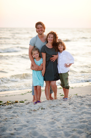 United family of four against the background of sea waves.の写真素材