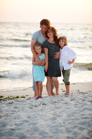 United family of four against the background of sea waves.の写真素材