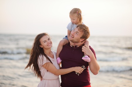 Happy young family against the sea.の写真素材