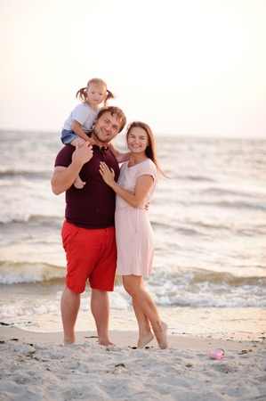 Happy young family against the sea.の写真素材