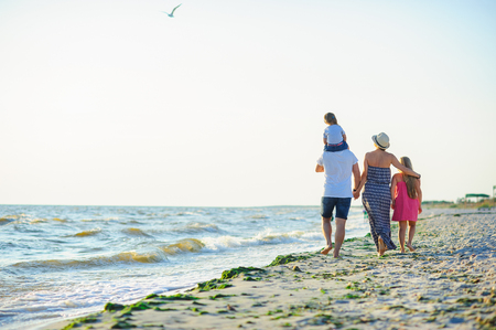 Family walks along the seaside. Desert beach, wet sand, sea waves. A unification with the nature.の写真素材