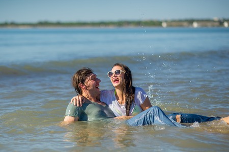 Young couple bathing in the sea. Guy and girl are merrily floundering in the water.の写真素材