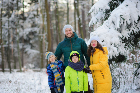 Family portrait in the winter forest. Happy family against the background of snow-covered trees.の写真素材