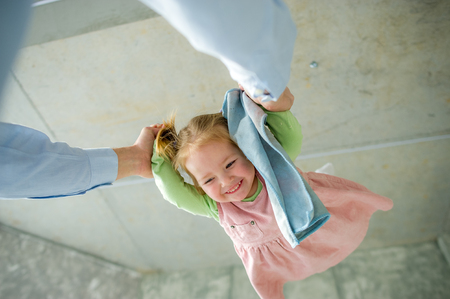 The father plays with the little daughter. The child laughs from pleasure.の写真素材