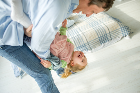 The father plays with the little daughter. The child laughs from pleasure.の写真素材