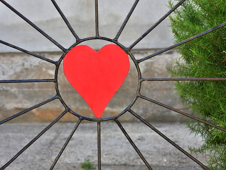 A big red heart in a metal fence in black colorの写真素材