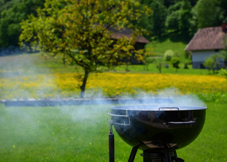 Summer picnic outdoor background. Bbq party. Cooking meat. No people. Horizontal photo with a lot of smoke from grill.の写真素材