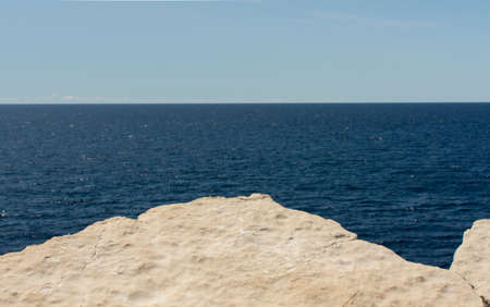 Beautiful minimalism horizontal photo of sea, rock and sky.の写真素材