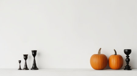 Halloween pumpkins and black candlesticks on a white backgroundの素材