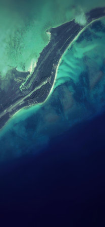 A stunning abstract image depicting a transition from textured turquoise green to deep navy blue, resembling an aerial view of a coastline or a fluid art creation.の写真素材