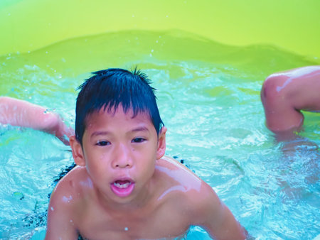 A boy playing in the pool and Smile happily.