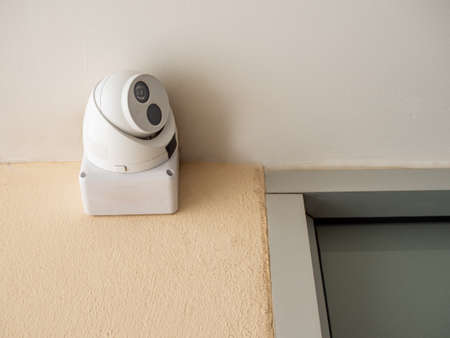 CCTV is located on the wall under the white ceiling.の写真素材