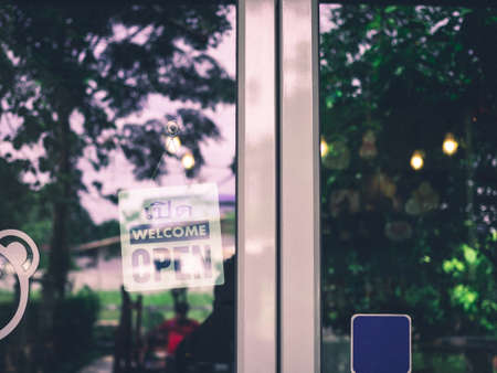 An open sign hangs behind the glass of a shop door. The idea of starting a business. busisness concept.の写真素材