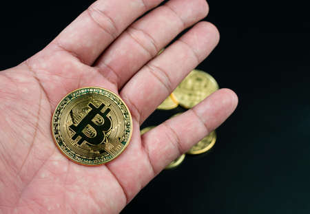 bitcoin coin placed on the hand on a black backgroundの写真素材