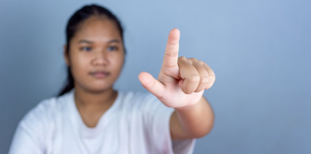 Female hand pushing a digital screen at white background. focus on finger.の写真素材
