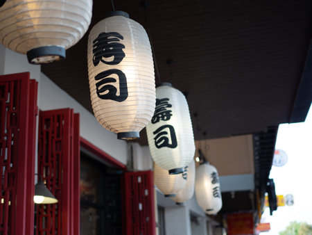 Japanese lantern hung in front of Japanese Restaurant, Japanese text on lantern is Sushi Japanese...