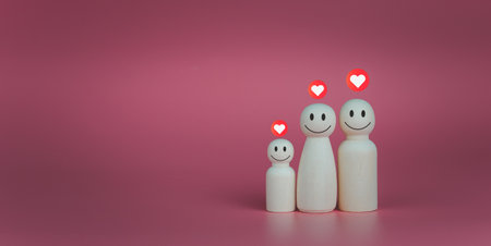 Happy house concept. Wooden dolls stand lined up with heart icons. Indicates happiness and love in the home.の写真素材