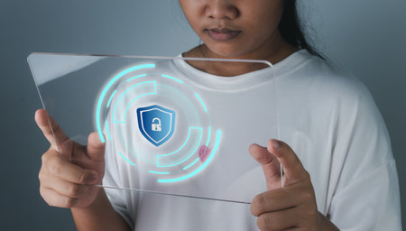 Woman holding phone tablet screen with protection icon. Represents protection against external hacks. Security concepts against code, virus, firmware and malware.の写真素材