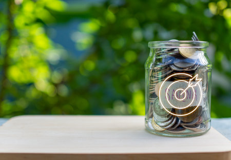 Coins in glass bottles on nature background. The concept of savings and investment.の写真素材