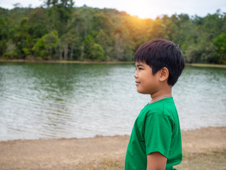 A boy stands by the reservoir in the evening. It shows looking at the goals in life.の写真素材