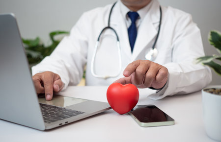 A Doctor holding and showing a red heart at hospital office. Medical health care and doctor staff service concept.の写真素材