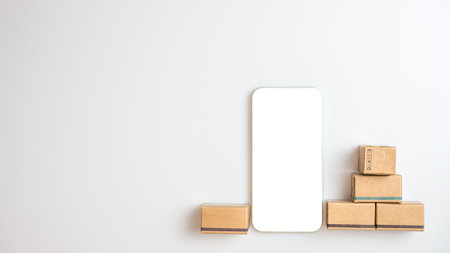 Shopping concept. Cardboard box and phone with blank screen on white background. Online shopping consumers can choose from home shopping and delivery services. with copy space.の写真素材