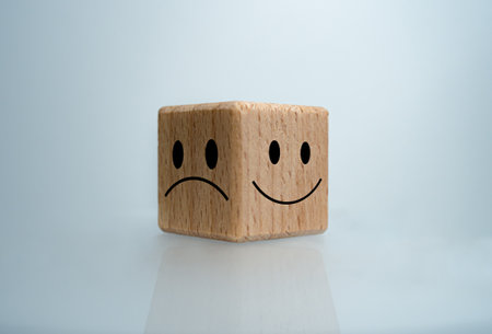 Mental health and emotional state concept, Smile face  and sad face on wooden block cube for positive mindset selection concept.の写真素材