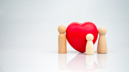 The concept of health insurance and Medical welfare. A wooden doll with a red heart on a white...