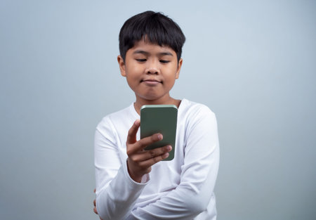 Social media and technology concepts. Boy's hands holding a smartphone and stylus pencil to use...