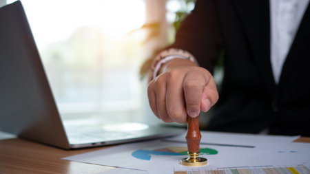 Businessman hand using wooden stamping to document approve and reject document or project, Signing a...