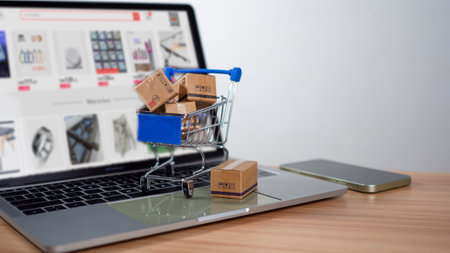 Shopping cart and product boxes placed on laptop computer represent online shopping concept, website, e-commerce, marketplace platform, technology, transportation, logistics and online payment concept.の写真素材