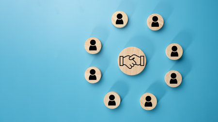 Team management concept, Human resources, Recruitment concept, HRM administration or human resource management concept, The handshake icon in a circular wooden board placed on a light blue background.の写真素材