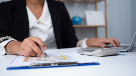 Business woman people use computers and paper documents to analyze business and manage corporate information. Business analysis with charts, indicators, and KPIs to improve organizational performance.の写真素材