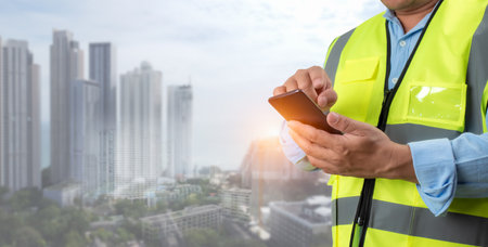Civil engineer architect Using a smartphone to communicate and give orders to the construction team, Engineer building concept, Background for construction, Technology to construction.の写真素材