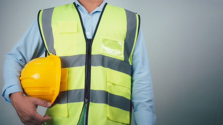 Civil engineer architect standing holding a safety helmet on grey background, Construction site plans to build high-rise buildings, Engineer building concept, Background for construction.の写真素材