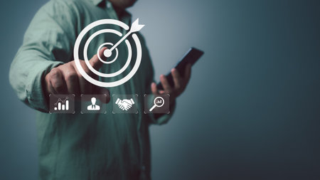 Businessman use smartphone with virtual target icon for strategic planning to business growth and target customer group, business objective,Targeting business concept, Business goal.の写真素材