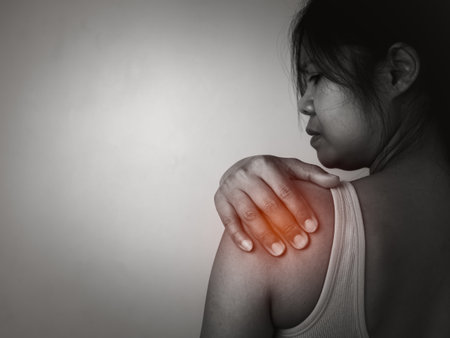 Woman with acute pain shoulder with neck pain on gray background, Shoulder inflammation and arm, Female massaging her shoulder muscle spasm, Healthcare and medical concept, Injuries and medical.の写真素材